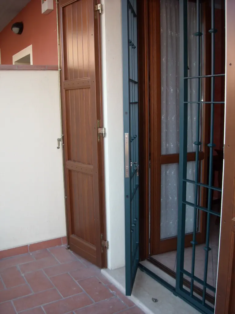 Cancelletto di sicurezza aperto su una portafinestra con persiana