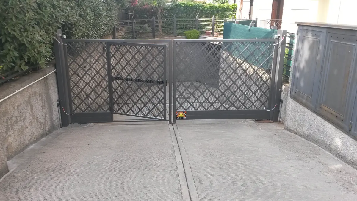 Cancello a due ante con pannelli in rete e automazione su un accesso carraio