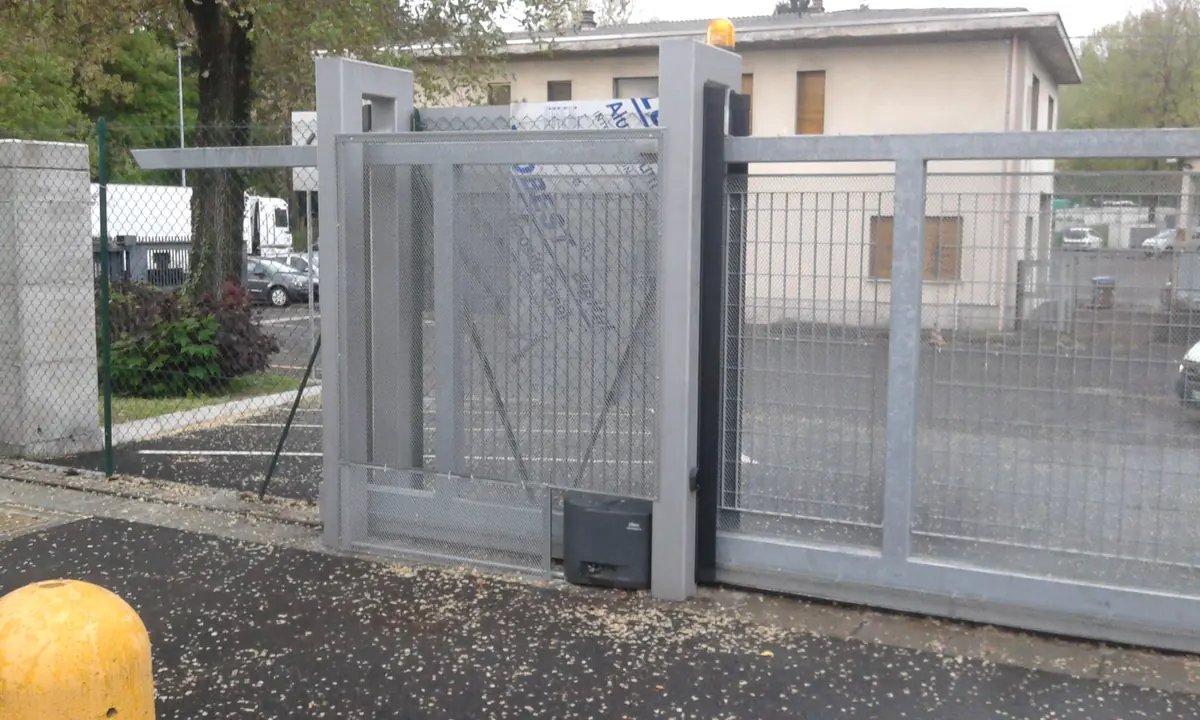 Cancello scorrevole automatico zincato con motore a cremagliera, all'ingresso di un'azienda