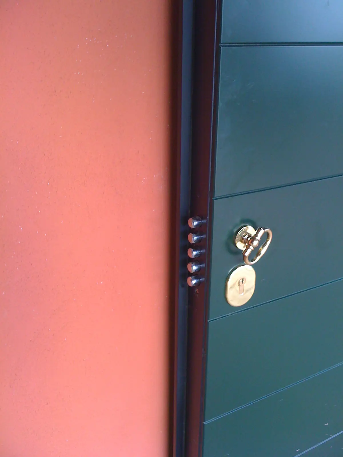 Particolare dei catenacci sul bordo di una porta blindata aperta