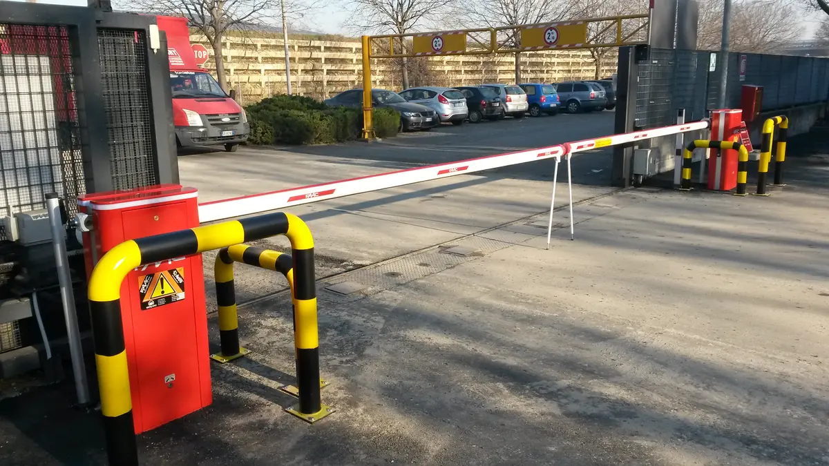 Sbarra automatica abbassata all'ingresso di un parcheggio aziendale, con protezioni paracolpi