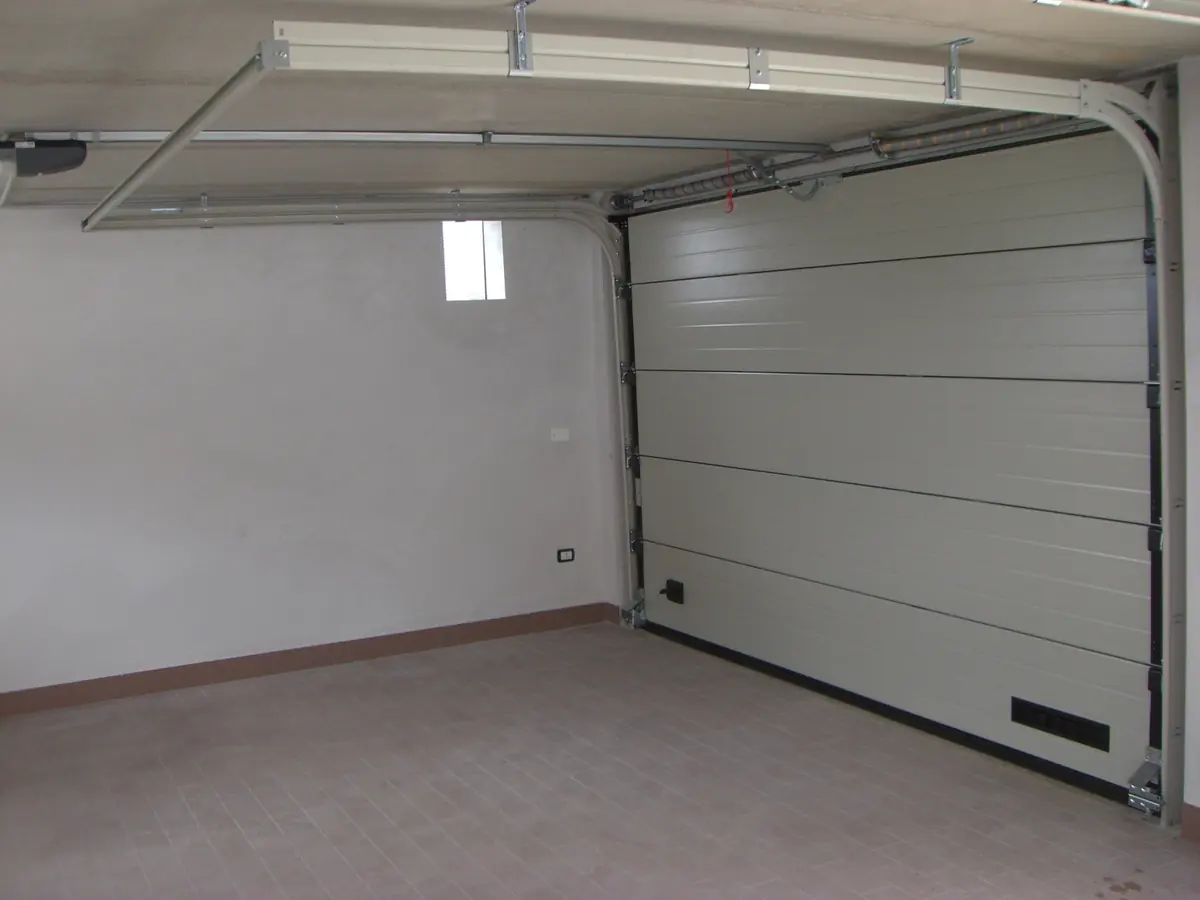 Interno di un portone sezionale chiuso, con guide laterali e a soffitto